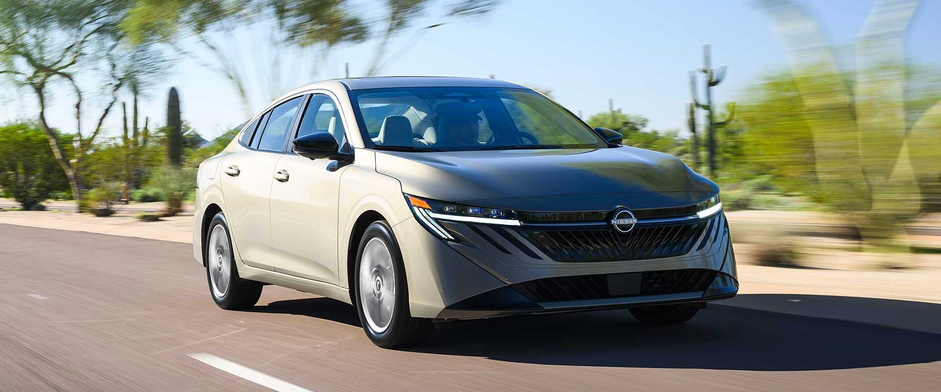 2026 Nissan Sentra driving on desert highway with cacti in background