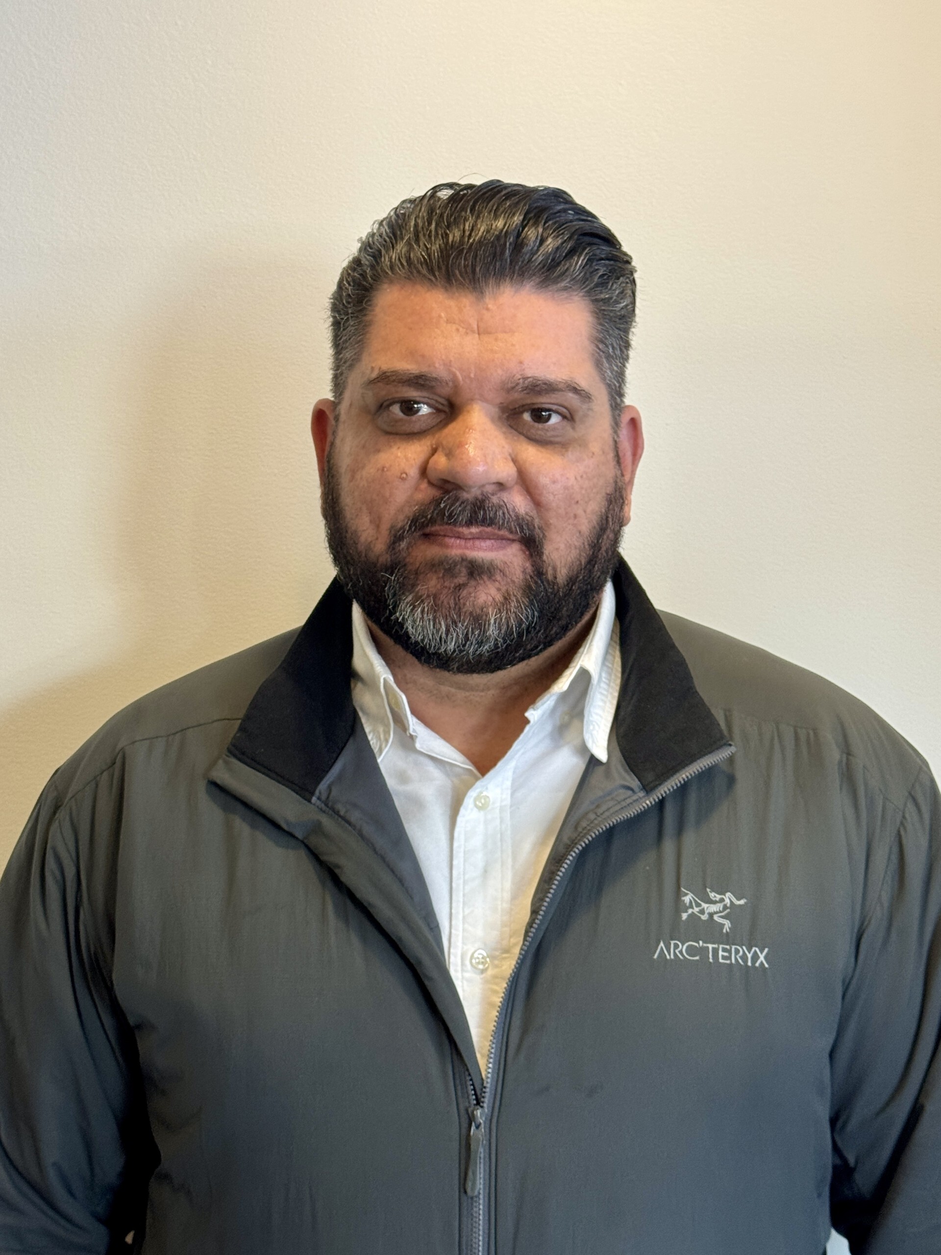 Professional headshot of staff member wearing Arc'teryx jacket over white shirt