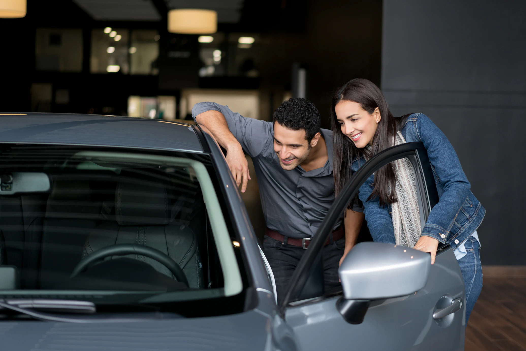 Family checking out a vehicle at a dealership showroom