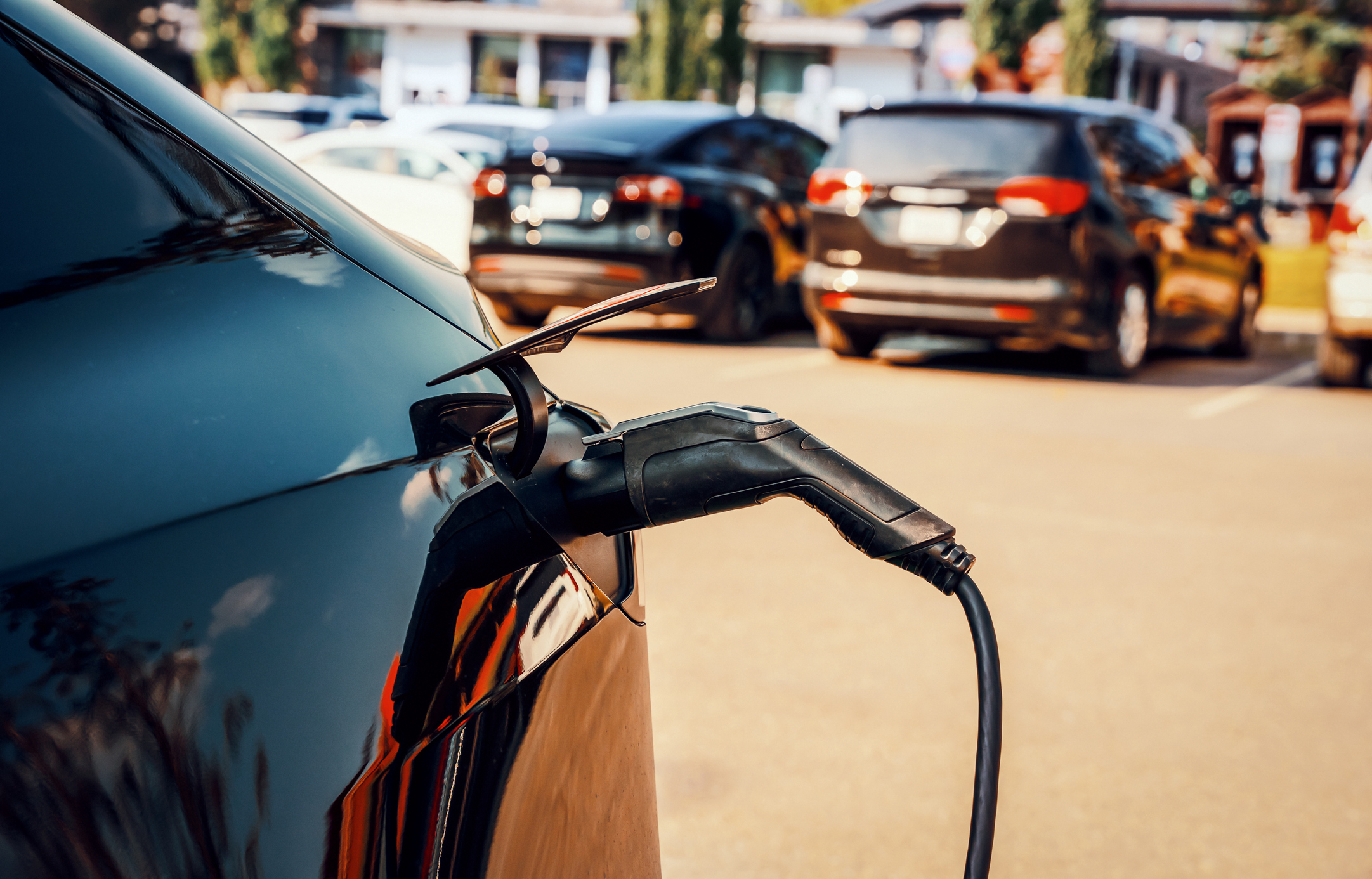 Electric vehicle charging outdoors at a public parking lot, illustrating EV ownership and charging in Canada.