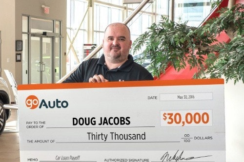 Photo of contest winner Doug Jacobs holding cheque