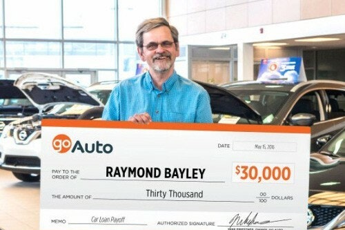 Photo of contest winner Raymond Bayley holding cheque
