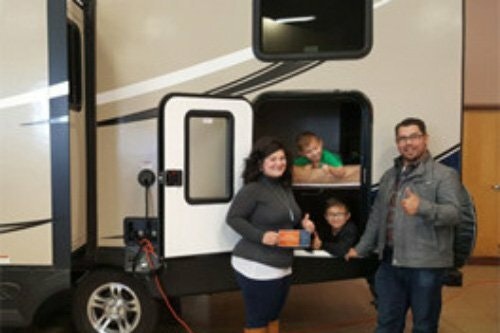 Photo of contest winner Stephania Desmarais and family with their week-long RV prize