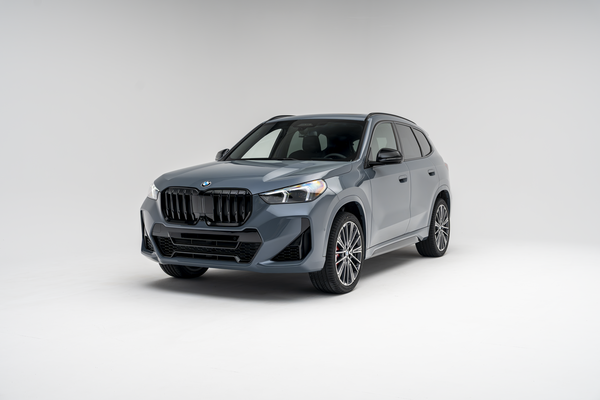 Front three-quarter view of a grey 2026 BMW X1 xDrive28i SUV on a white studio background.