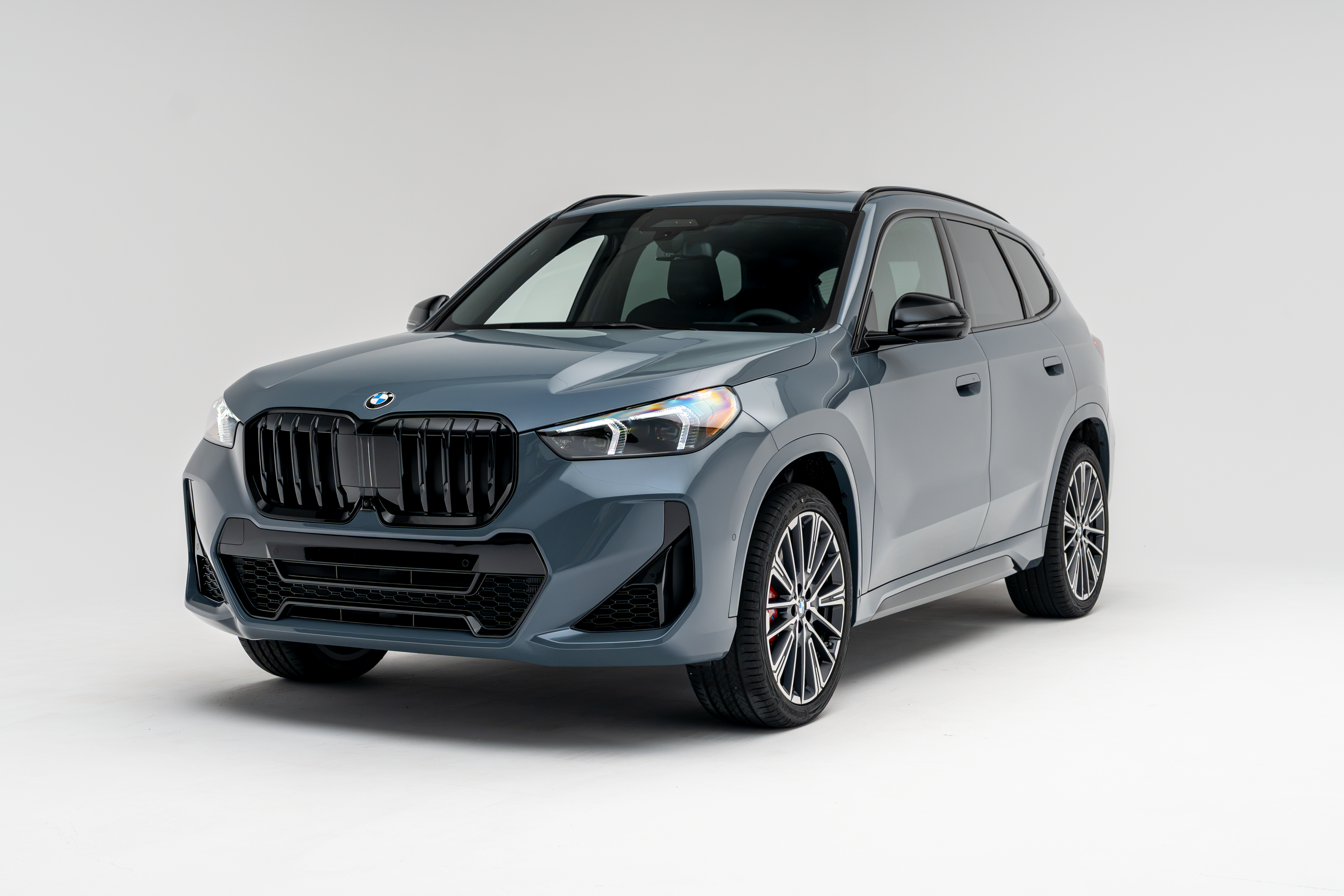Front three-quarter view of a grey 2026 BMW X1 xDrive28i SUV on a white studio background.