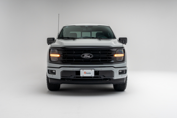 White Ford F-150 pickup truck front view with headlights on