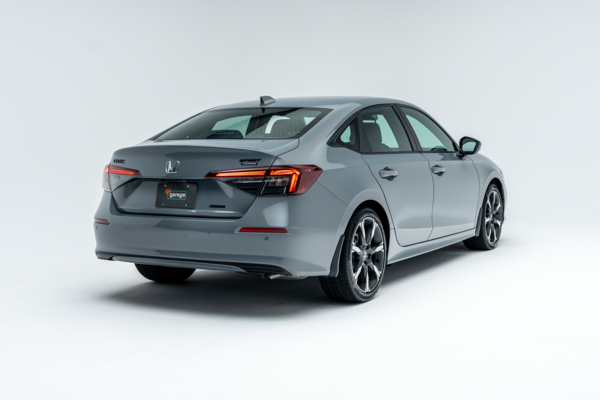 Rear three-quarter view of a grey 2026 Honda Civic showing taillights, alloy wheels and side profile.