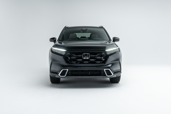 Front view of a black 2026 Honda CR-V SUV with LED headlights illuminated on a white studio background.