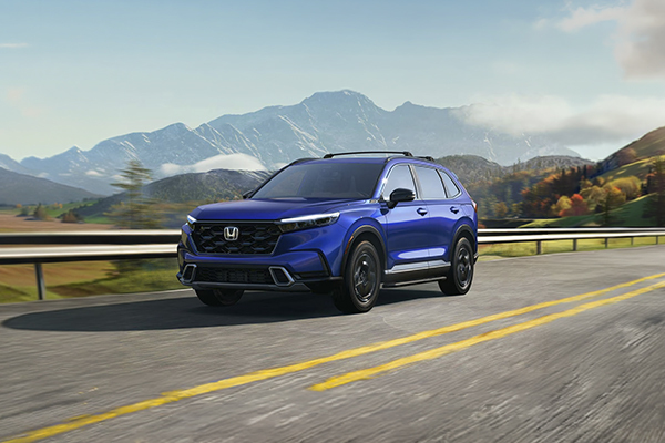 Blue Honda CR-V driving on a mountain highway with scenic landscape background