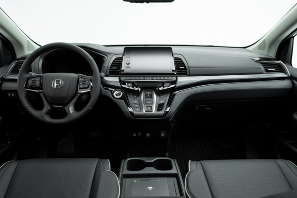 2026 Honda Odyssey Touring dashboard with steering wheel, infotainment display, centre controls and cupholders.