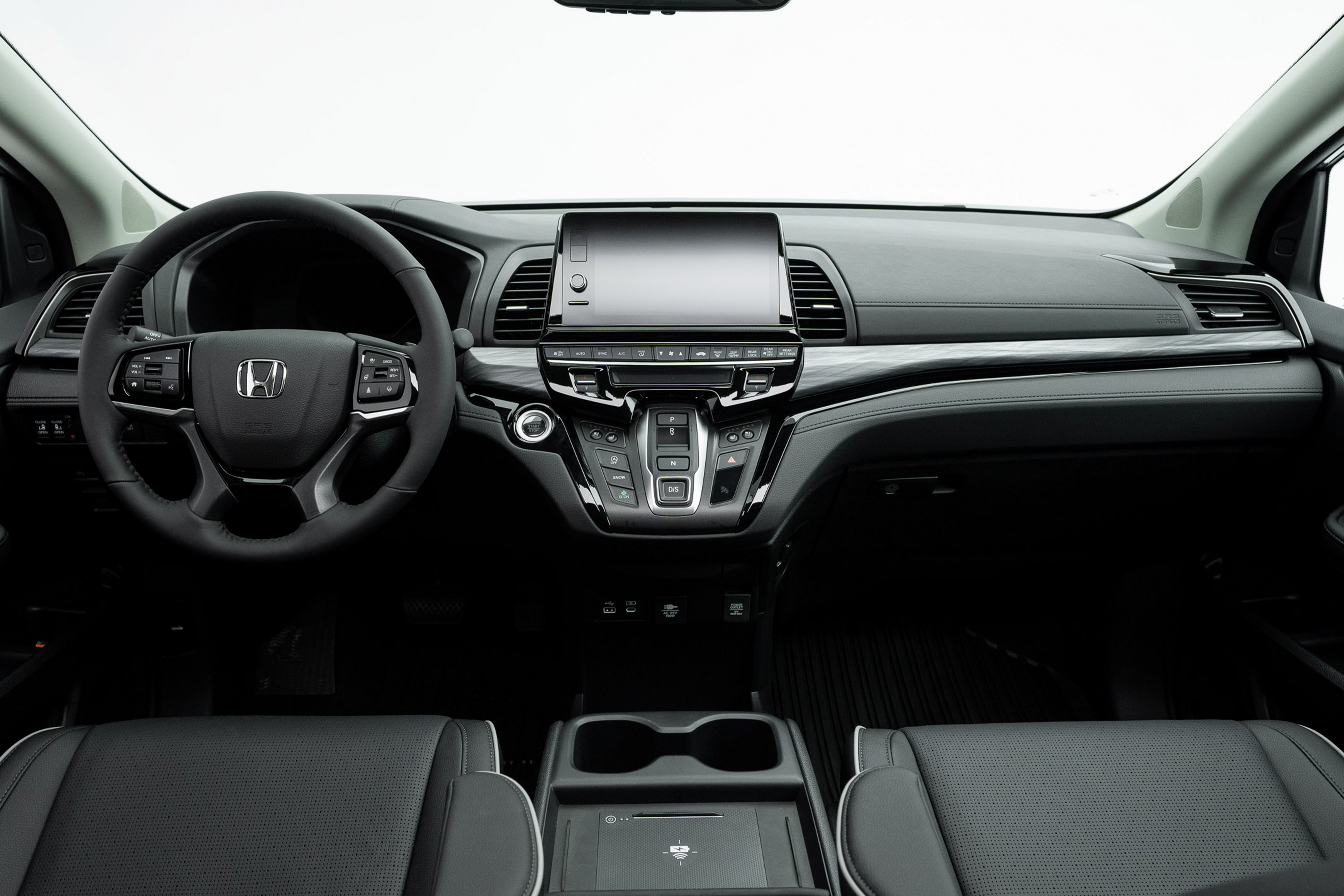 2026 Honda Odyssey Touring dashboard with steering wheel, infotainment display, centre controls and cupholders.