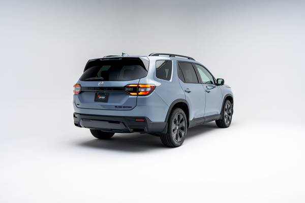 2026 Honda Pilot three-row SUV shown from rear three-quarter angle in light blue