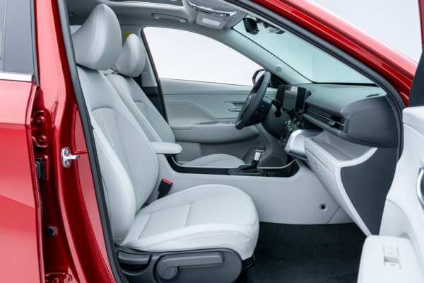 2026 Hyundai Kona front interior with light-coloured seats, dashboard, centre console and digital displays.