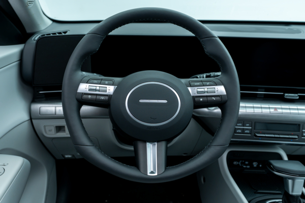 2026 Hyundai Kona steering wheel with driver controls, digital instrument display and dashboard.