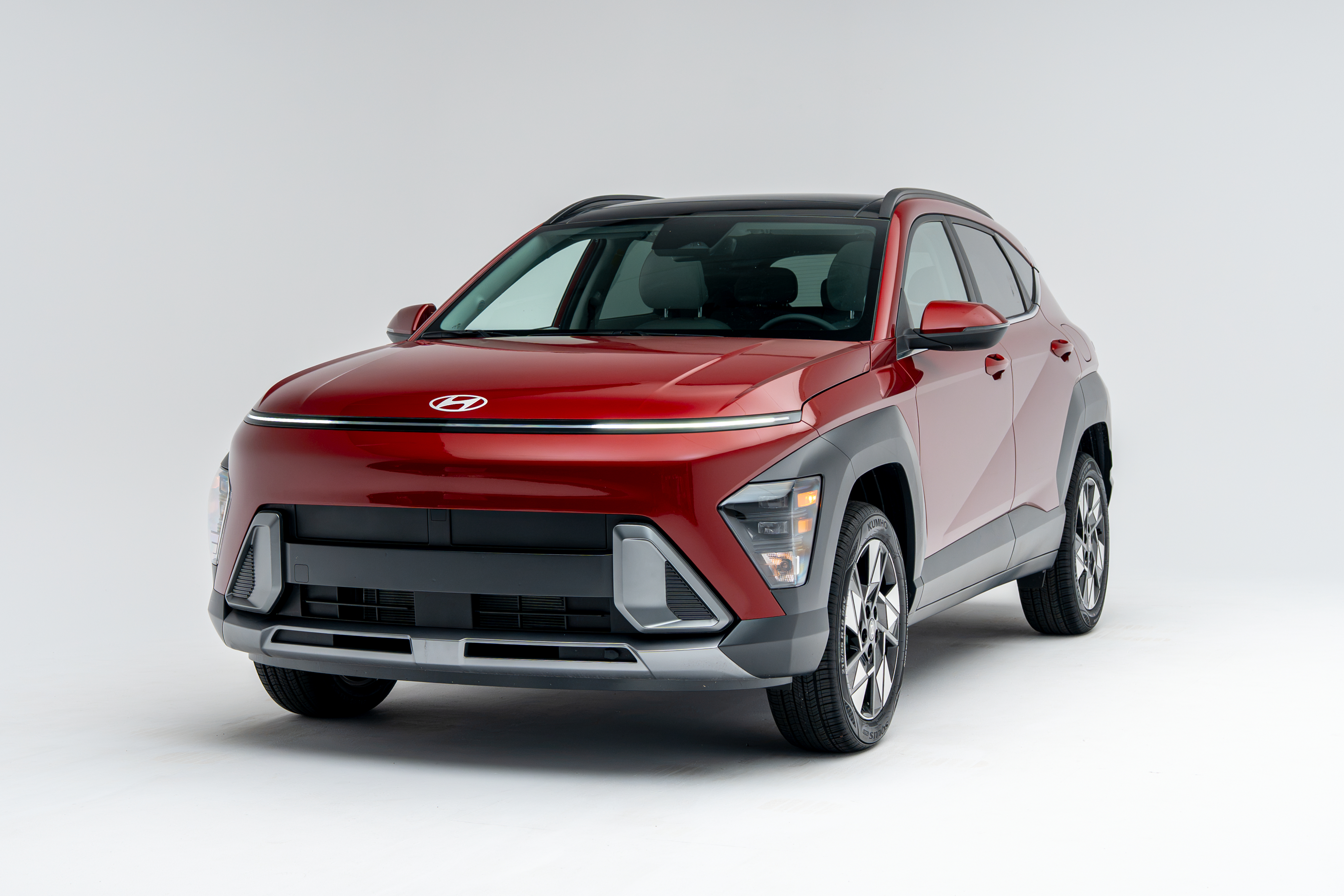 Front three-quarter view of a red 2026 Hyundai Kona SUV on a white studio background.