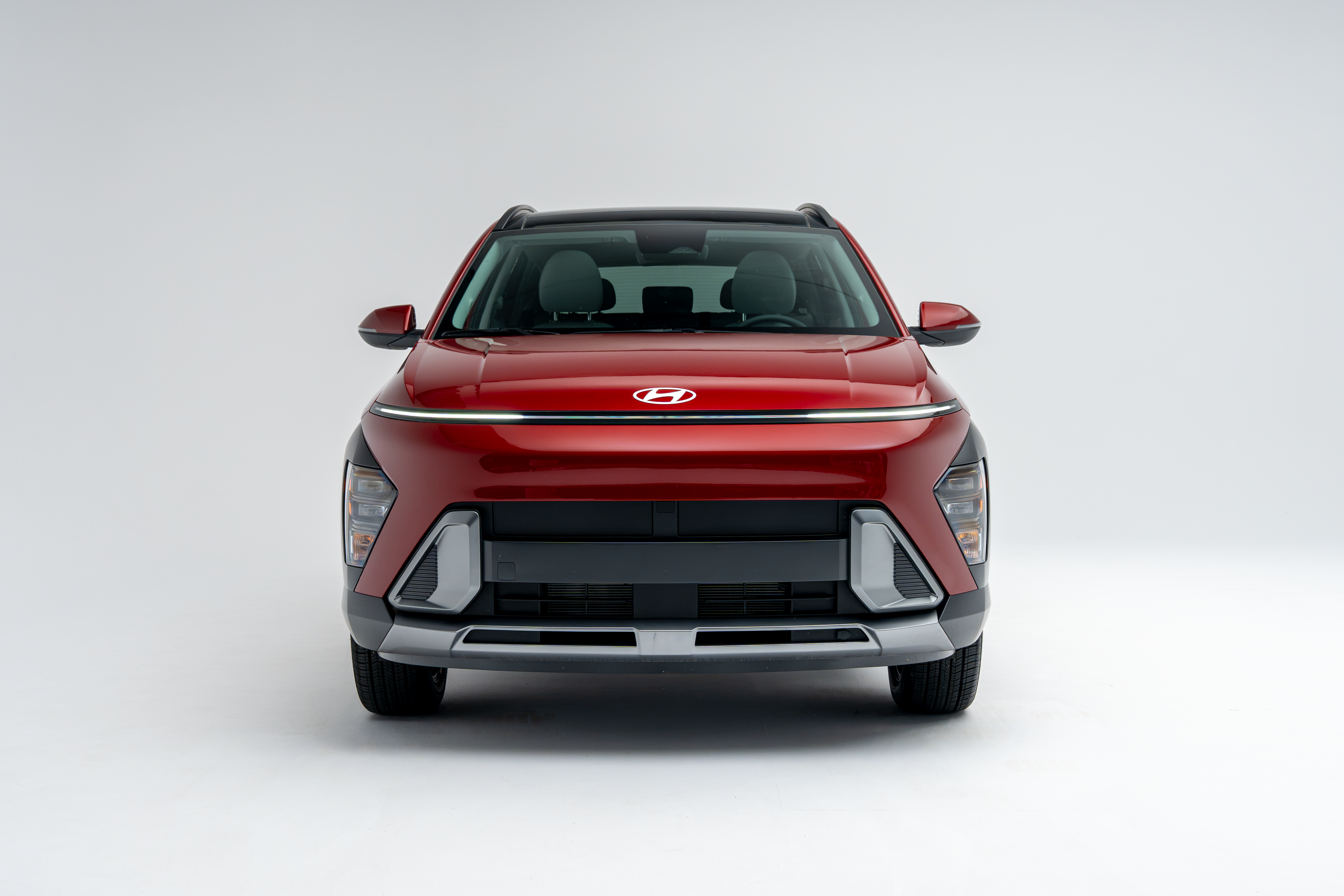 Front view of a red 2026 Hyundai Kona SUV on a white studio background.