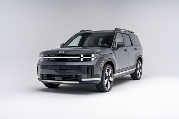 Front three-quarter view of a grey 2026 Hyundai Santa Fe Hybrid SUV on a white studio background.