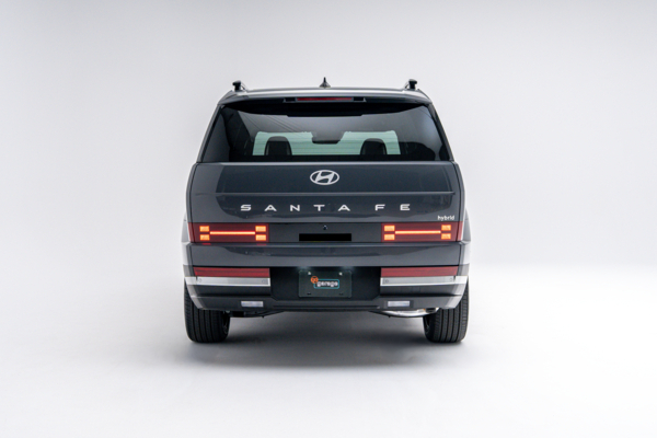 Rear view of a grey 2026 Hyundai Santa Fe Hybrid showing LED taillights, Santa Fe badging and boxy SUV design.