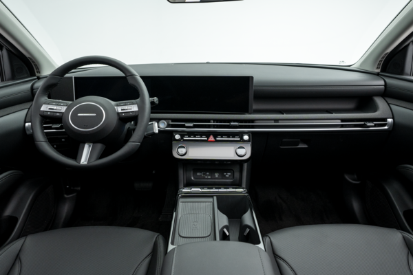 2026 Hyundai Tucson interior featuring a black dashboard, steering wheel, digital display, centre console and front seats.