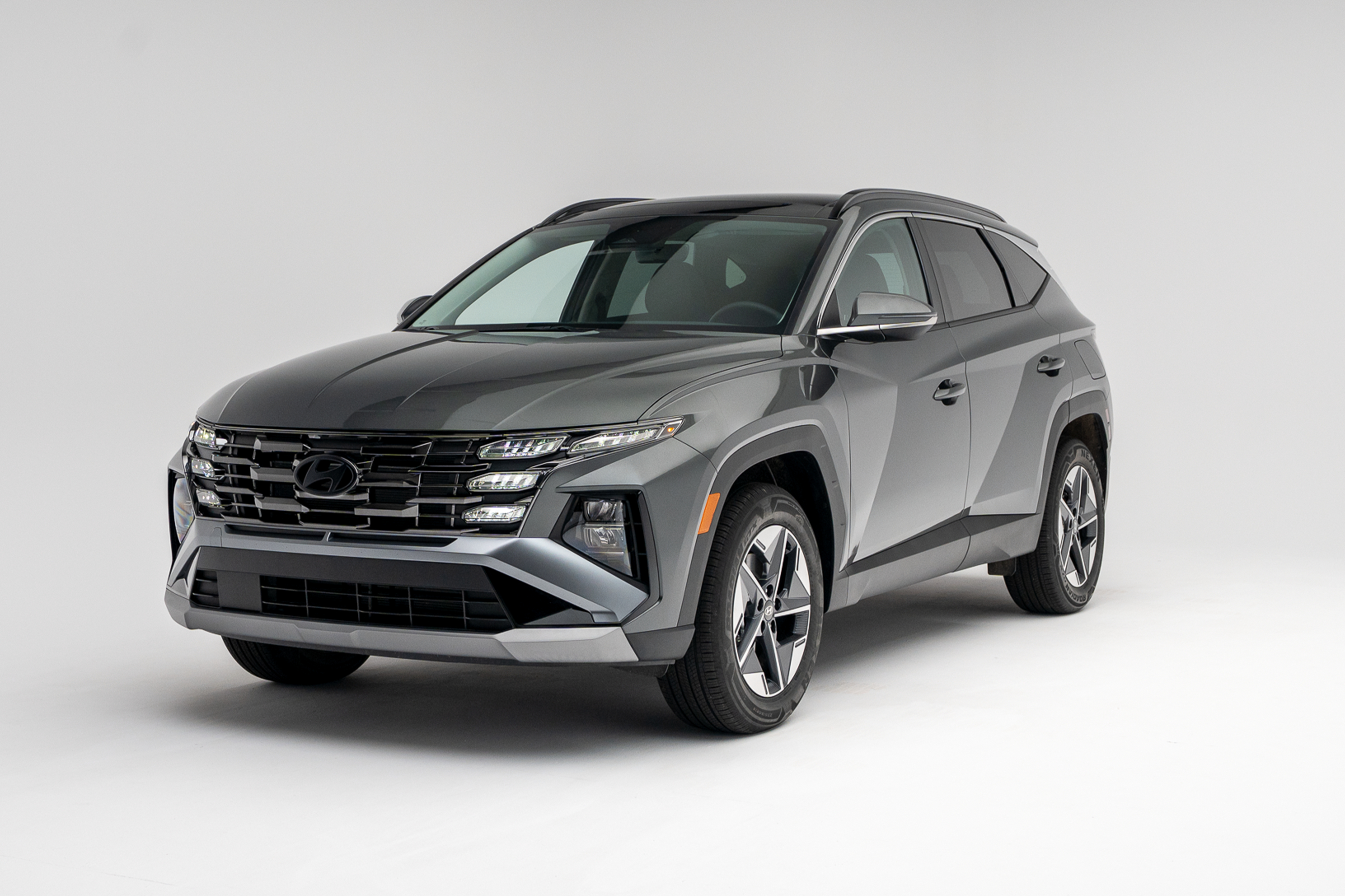 2026 Hyundai Tucson in grey, shown from a front three-quarter angle against a white studio background.