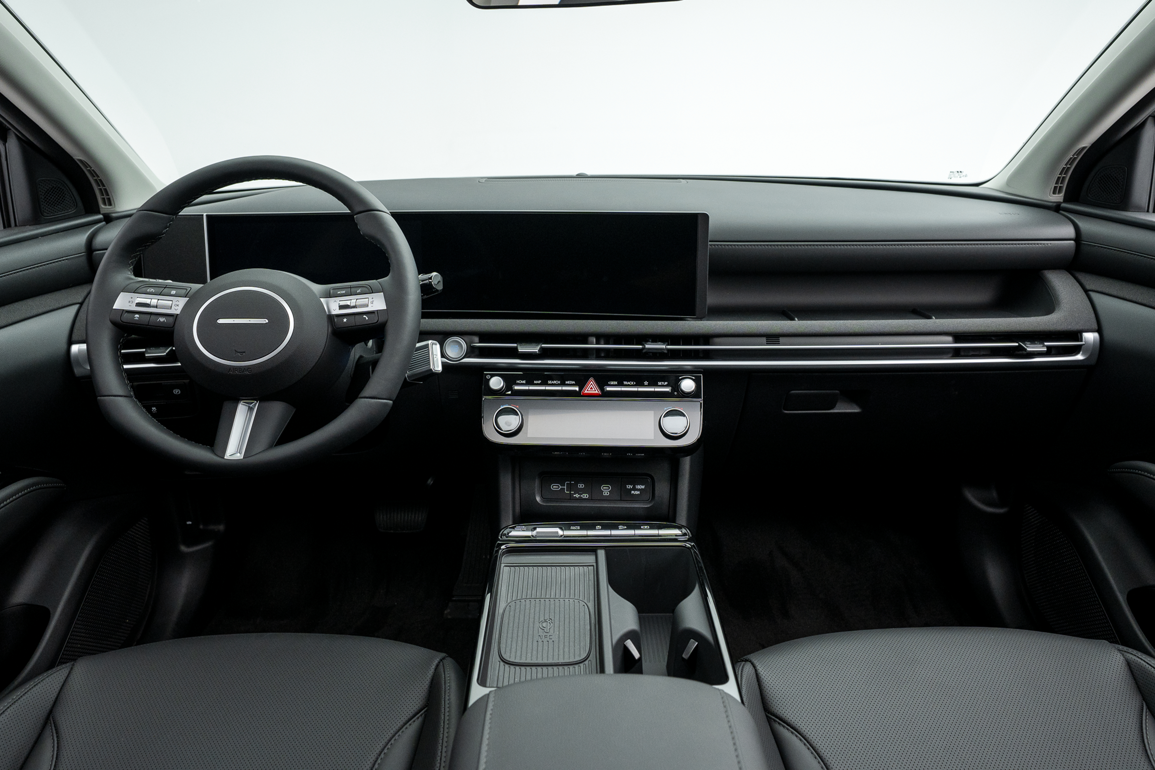 2026 Hyundai Tucson interior featuring a black dashboard, steering wheel, digital display, centre console and front seats.