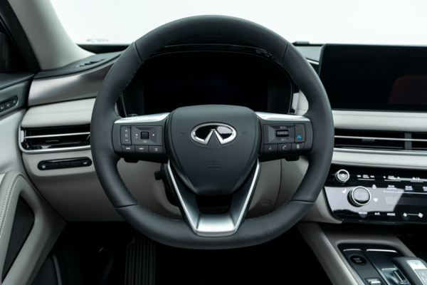 2026 Infiniti QX60 steering wheel with driver controls, digital instrument display and dashboard.