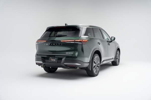 Rear three-quarter view of a 2026 Infiniti QX60 showing LED taillights, alloy wheels and SUV profile.