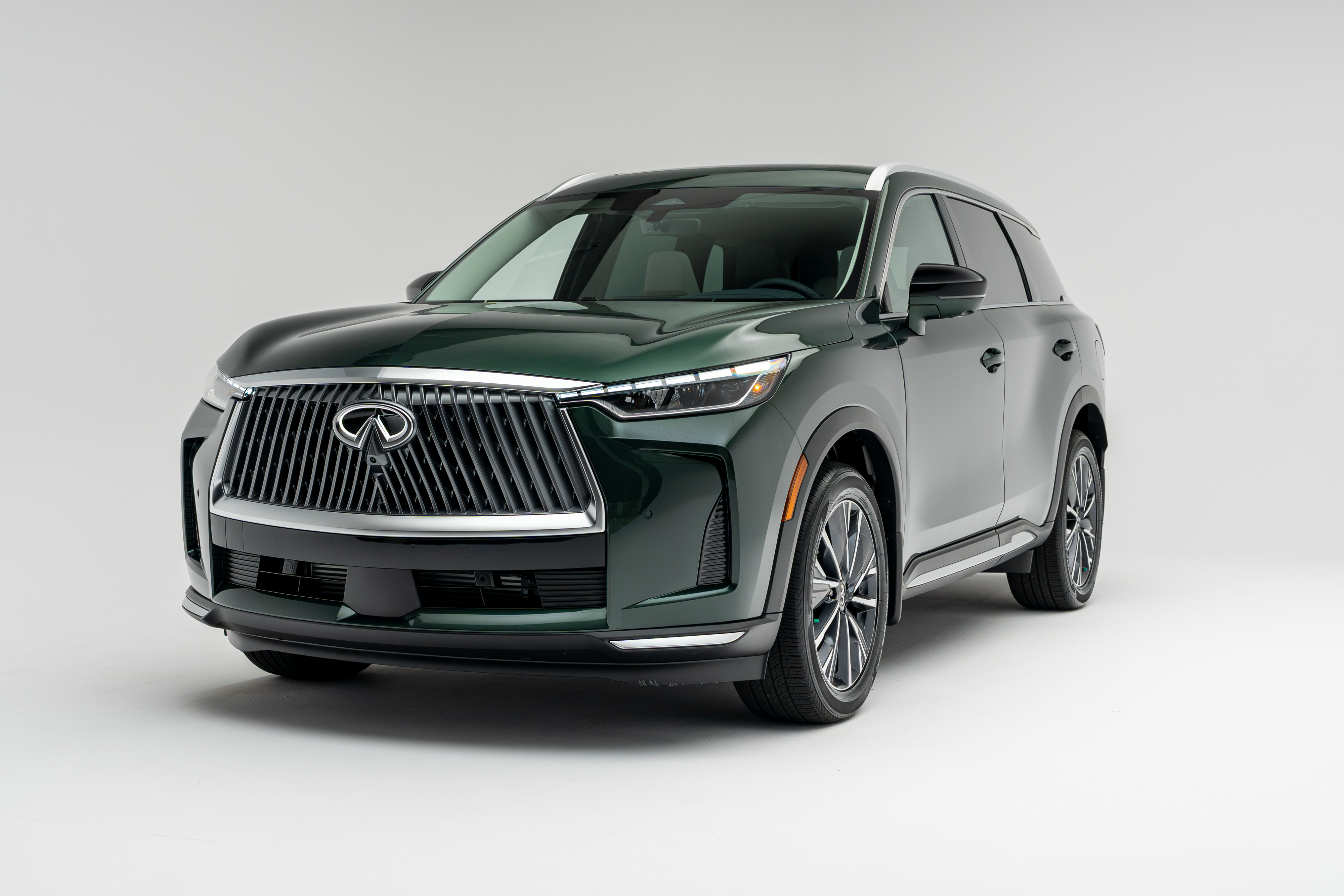 Front three-quarter view of a 2026 Infiniti QX60 showing LED headlights, grille, alloy wheels and SUV profile.