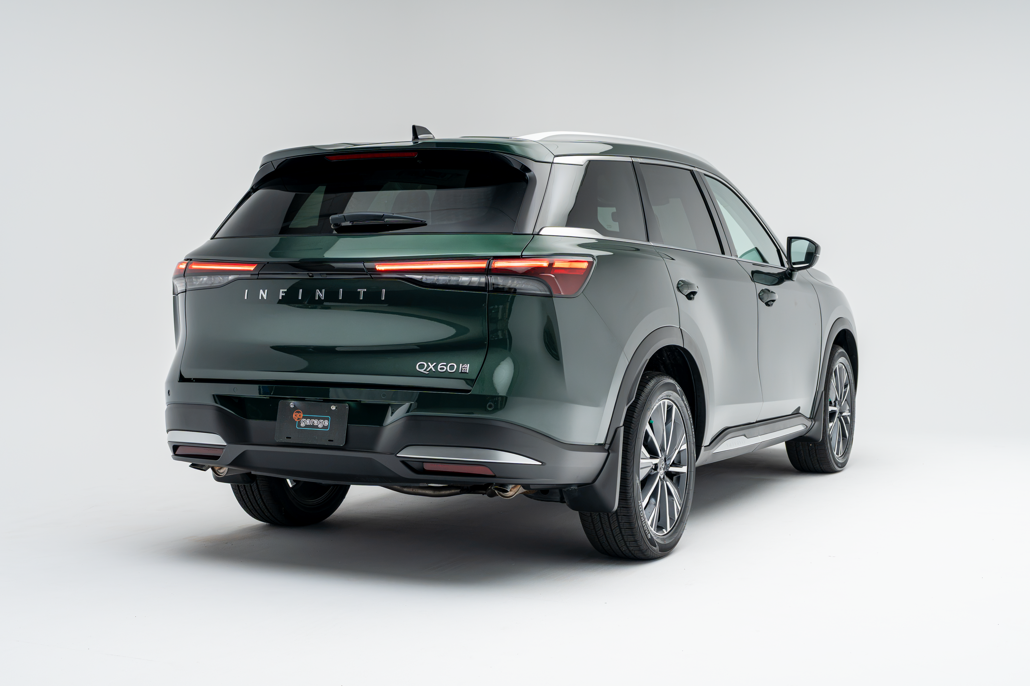 Rear three-quarter view of a 2026 Infiniti QX60 showing LED taillights, alloy wheels and SUV profile.