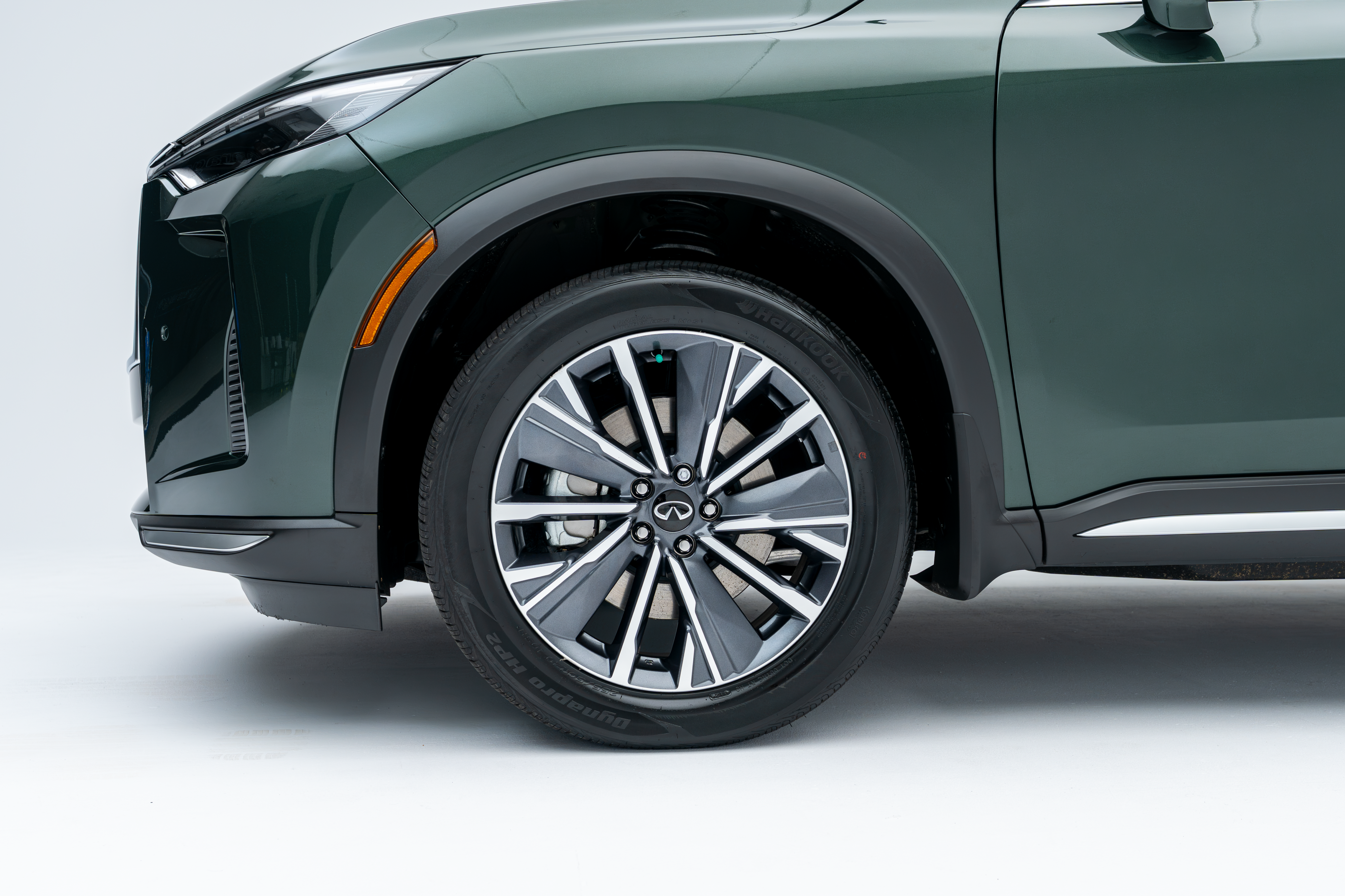 Close-up of a 2026 Infiniti QX60 alloy wheel, tire and front fender.