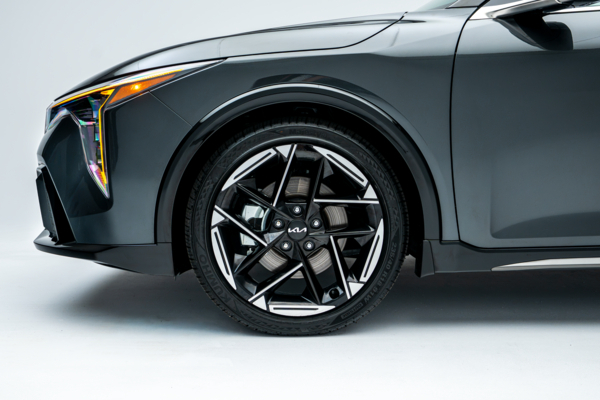 Close-up of a 2026 Kia K4 alloy wheel, tire and front fender.