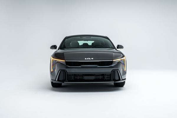 Front view of a grey 2026 Kia K4 showing LED headlights, grille and front fascia.