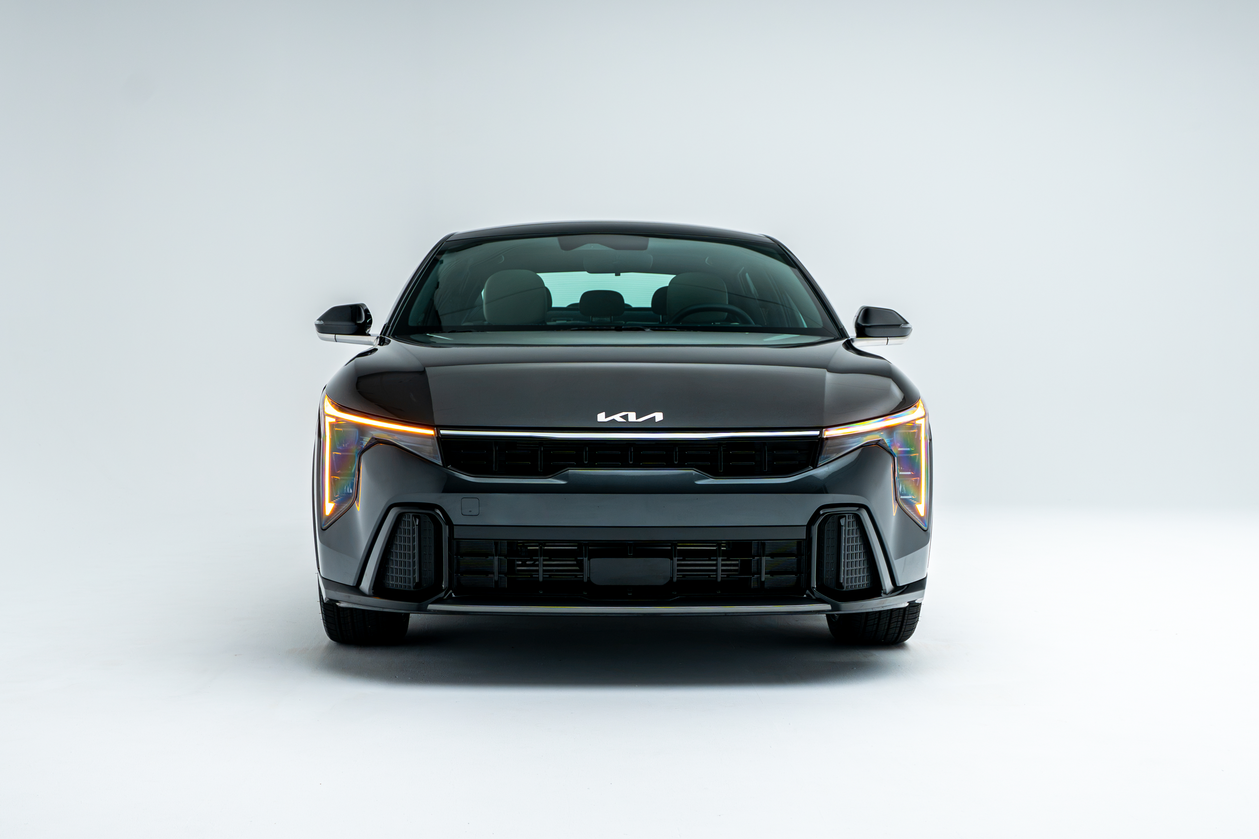 Front view of a grey 2026 Kia K4 showing LED headlights, grille and front fascia.