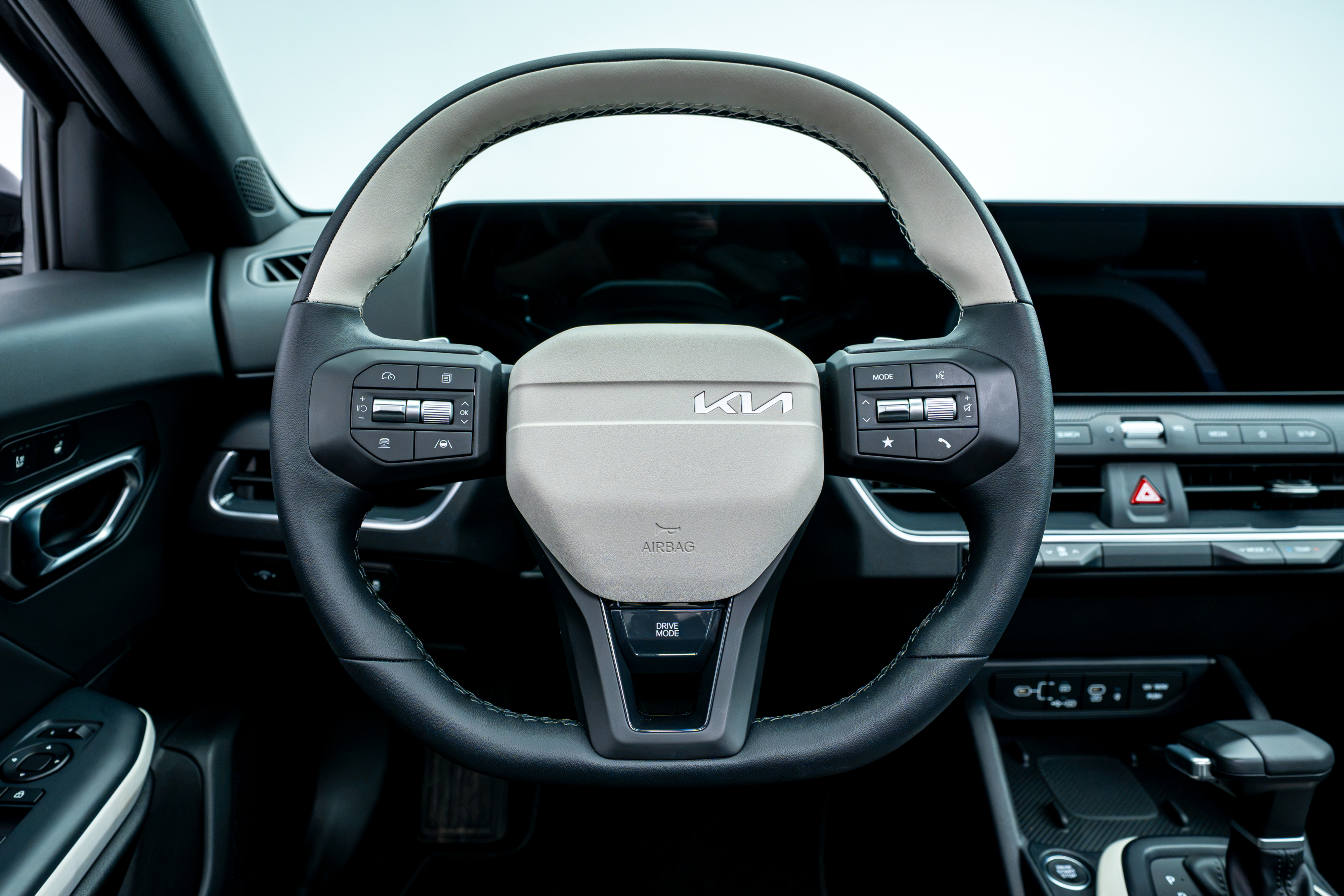 2026 Kia K4 steering wheel with driver controls, digital instrument display and dashboard.