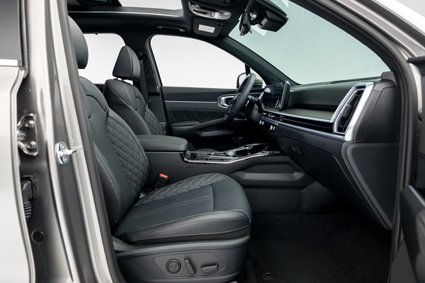 2026 Kia Sorento front interior with black seats, dashboard, centre console and panoramic sunroof.