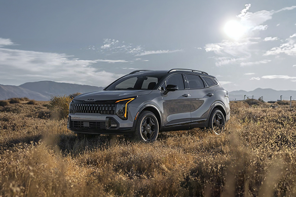 Kia Sportage parked in desert landscape with mountains in background