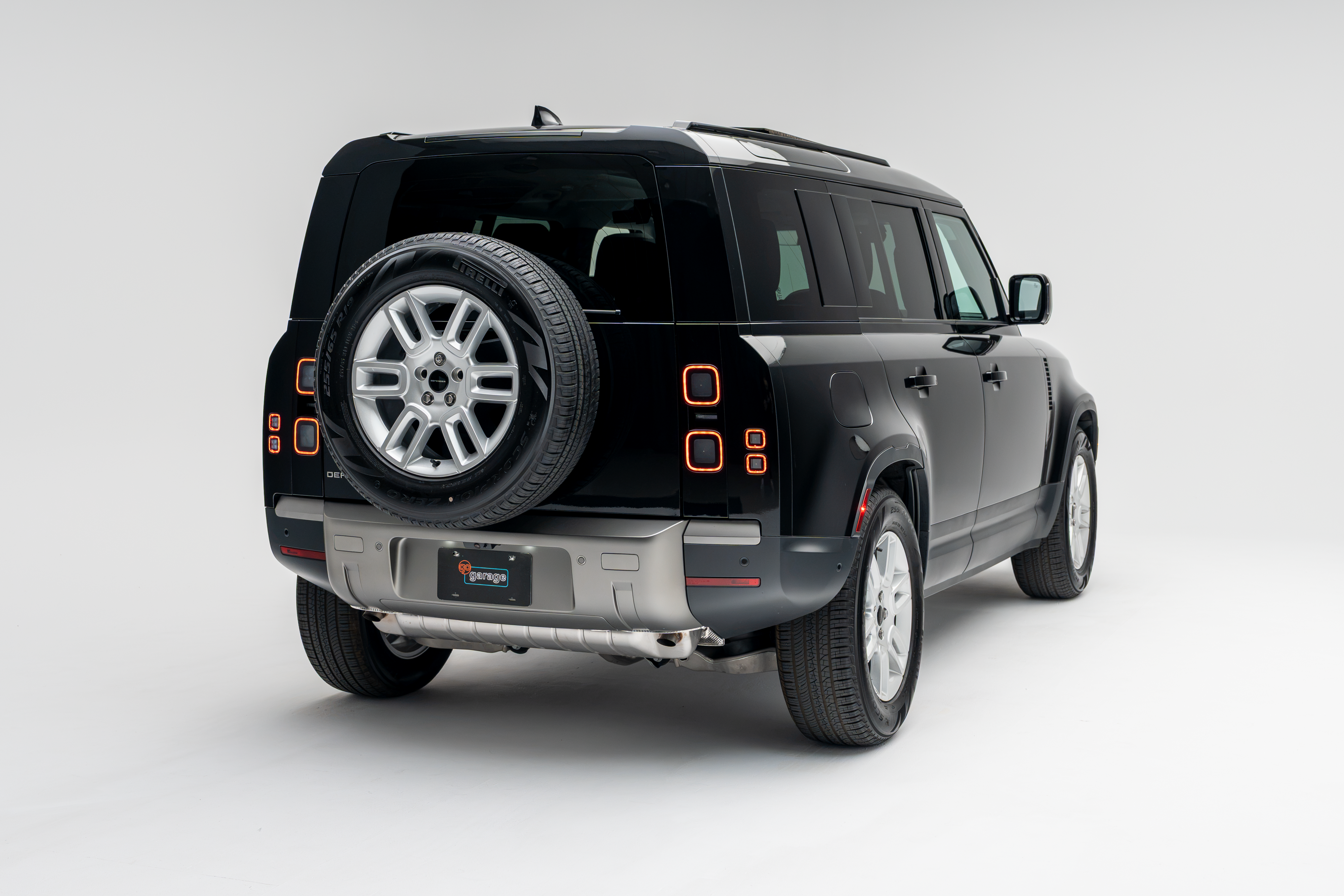 2026 Land Rover Defender 110 S rear three-quarter exterior view with rear-mounted spare tire