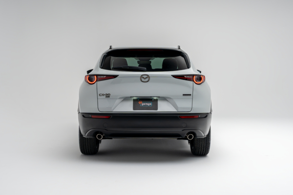Rear view of a white 2026 Mazda CX-30 showing LED taillights, CX-30 badging and dual exhaust outlets.