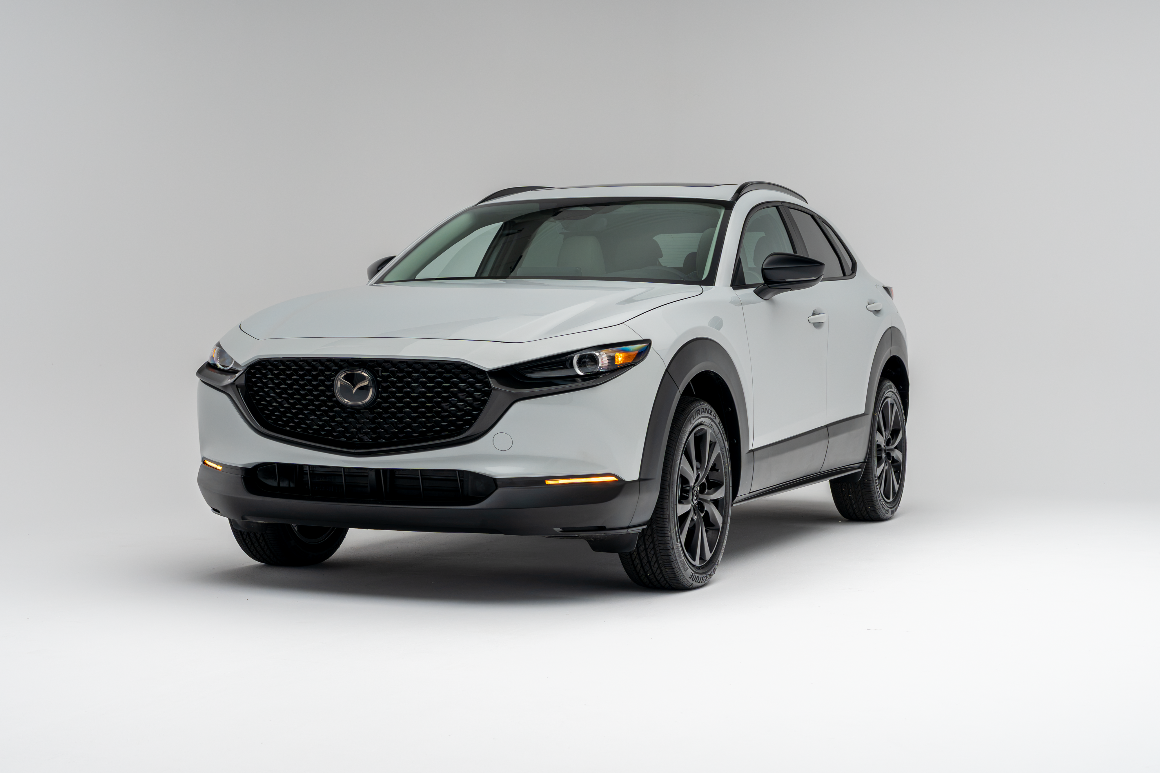 Front three-quarter view of a white 2026 Mazda CX-30 showing LED headlights, grille, alloy wheels and compact SUV profile.