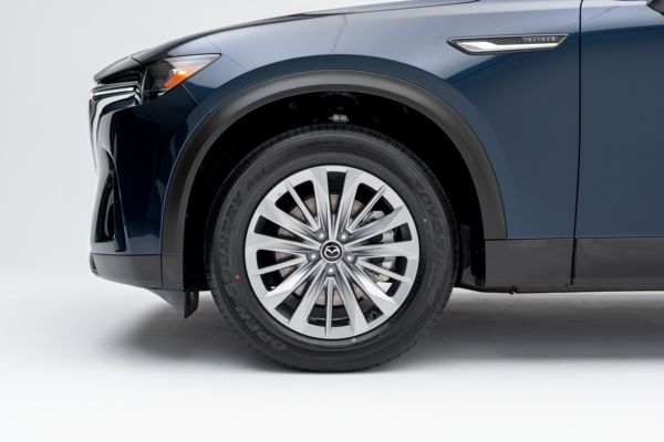 Close-up of a 2026 Mazda CX-90 alloy wheel, tire and front fender.