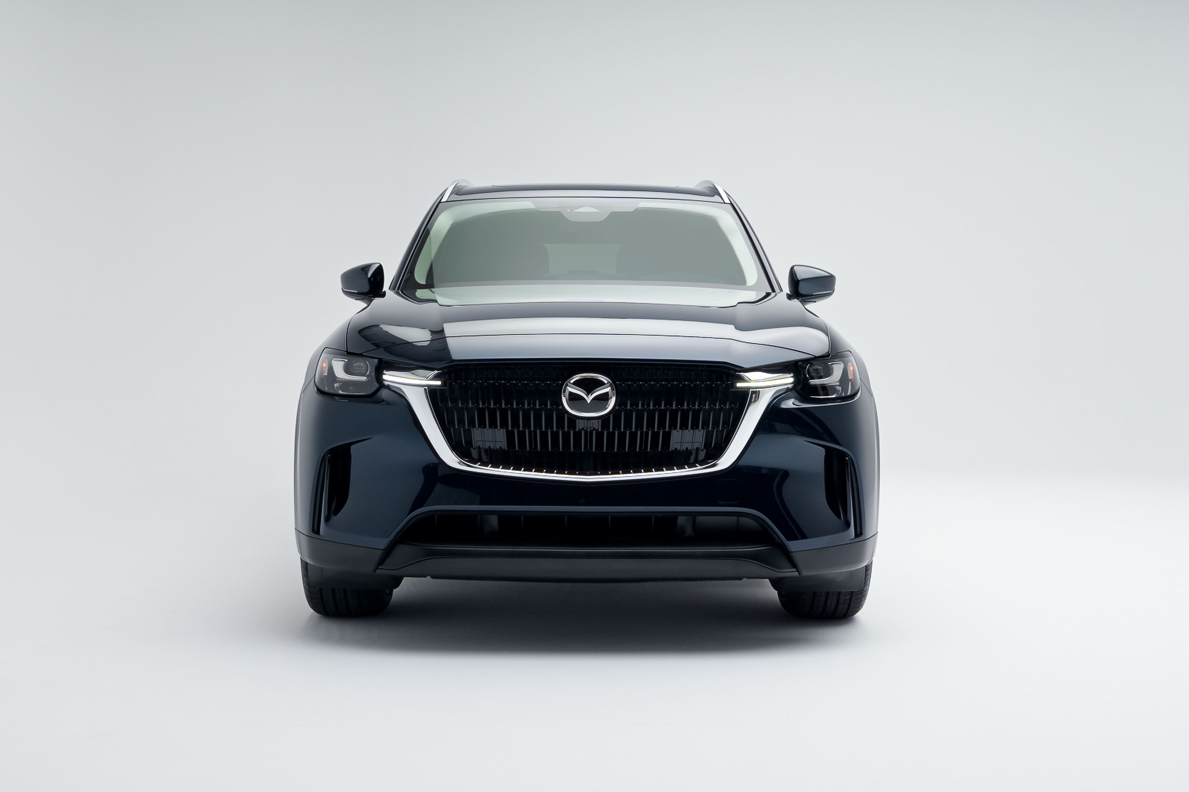 Front view of a blue 2026 Mazda CX-90 showing LED headlights, grille and front fascia.