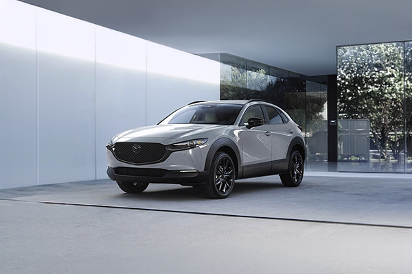 White Mazda CX-30 parked in modern showroom with minimalist interior design