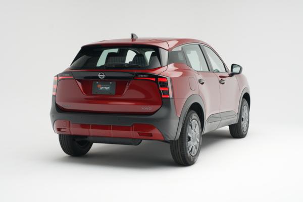 Rear three-quarter view of a red 2026 Nissan Kicks showing LED taillights, alloy wheels and compact SUV profile.