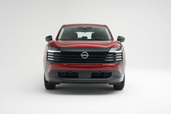 2026 Nissan Kicks in red, shown from a straight-on front view against a white studio background.