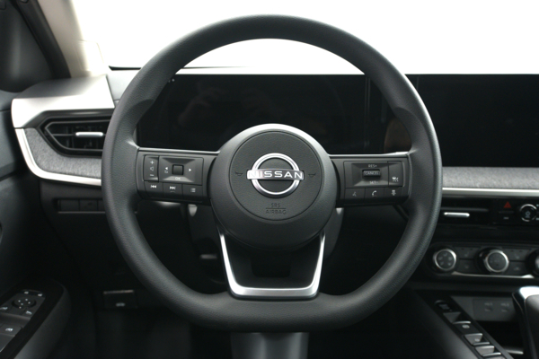 2026 Nissan Kicks steering wheel with driver controls, digital instrument display and infotainment screen.