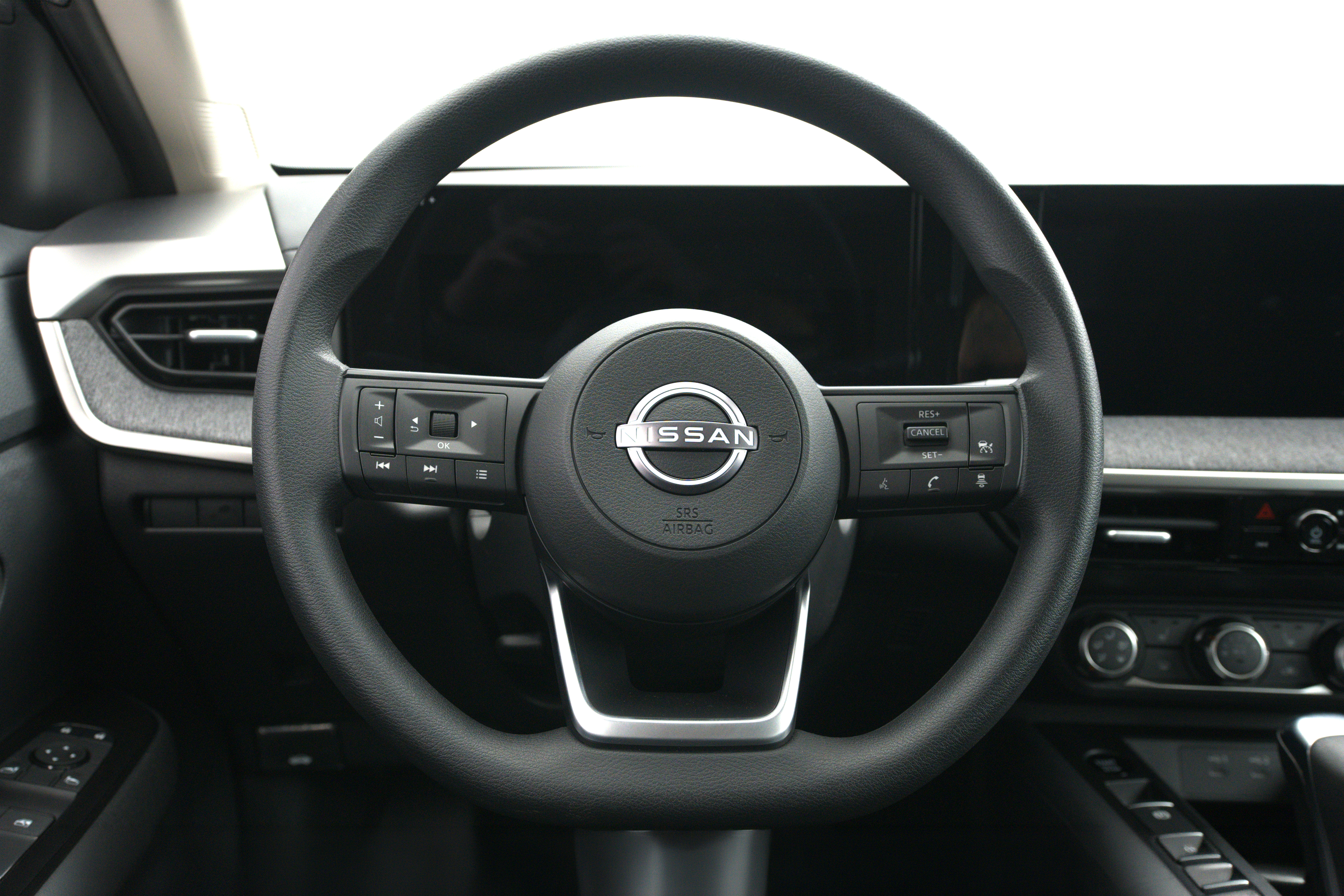 2026 Nissan Kicks steering wheel with driver controls, digital instrument display and infotainment screen.