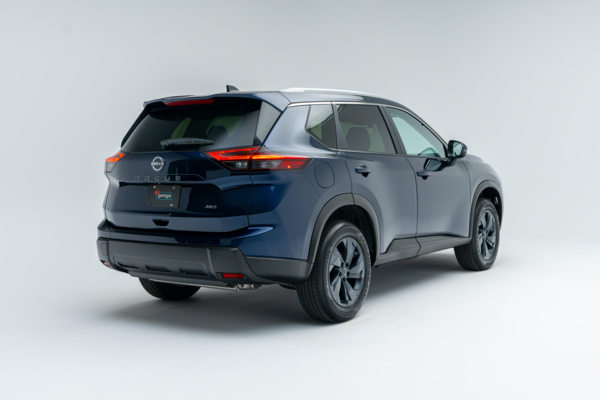 Rear three-quarter view of a blue Nissan Rogue SV Moonroof showing LED taillights, alloy wheels and SUV profile.