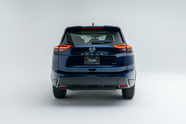 Rear view of a blue Nissan Rogue SV Moonroof showing LED taillights, Rogue badging and AWD badging.