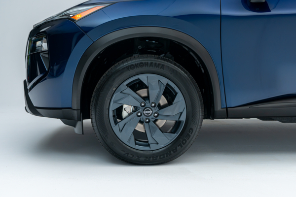 Close-up of a Nissan Rogue SV Moonroof alloy wheel, tire and front fender.