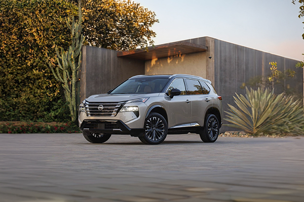 2025 Nissan Rogue parked in front of modern architecture with desert landscaping